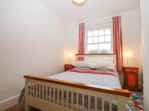 a small bedroom with a crib and a window at Solent Sea View in Fareham