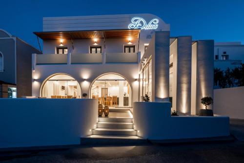 ein großes weißes Gebäude mit Lichtern in der Nacht in der Unterkunft Deluxe Hotel Santorini in Fira