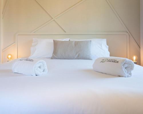 a white bed with two towels on top of it at Quinta de Carcavelos Natures Home in Amarante
