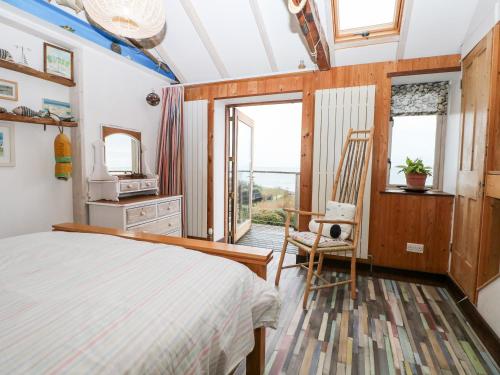 ein Schlafzimmer mit einem Bett, einem Stuhl und einem Fenster in der Unterkunft Cowes View Cottage in Fareham