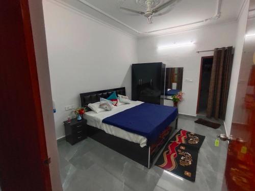 Un dormitorio con una cama con una manta azul. en Khajuraho Glory Homestay, en Khajurāho