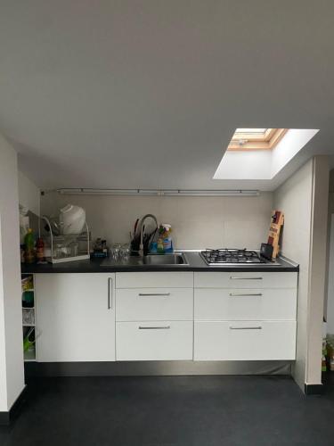 a kitchen with white cabinets and a stove top oven at Bogliasco Wine Loft in Bogliasco