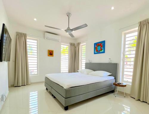 1 dormitorio con 1 cama y ventilador de techo en Apartment in luxury villa with private pool, en Willemstad