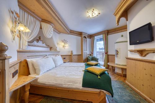 a bedroom with a large bed and a tv at La Torretta in Passo del Tonale