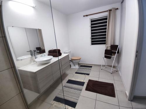 a bathroom with a sink and a glass shower at Elégant F3 à la Villa Stencer, Papeete, calme climatisé et spacieux in Papeete