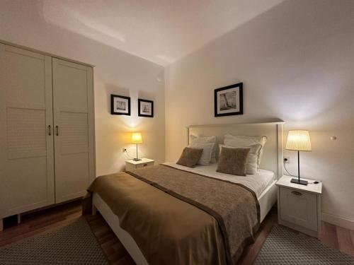 a bedroom with a large bed with two lamps at Just Studios in Varna City