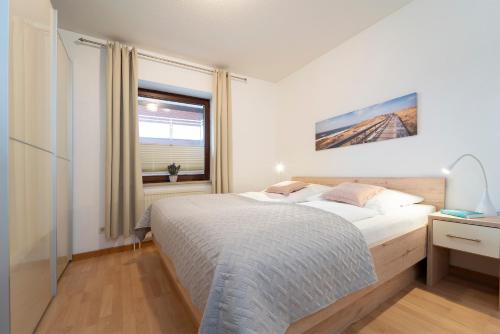 um quarto com uma cama grande e uma janela em Strandburg Wohnung 5 em Scharbeutz