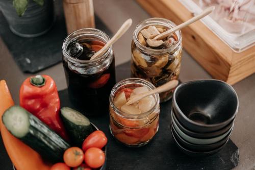 a table with three jars of food and vegetables at Alpenappartements Cristall in Ehrwald