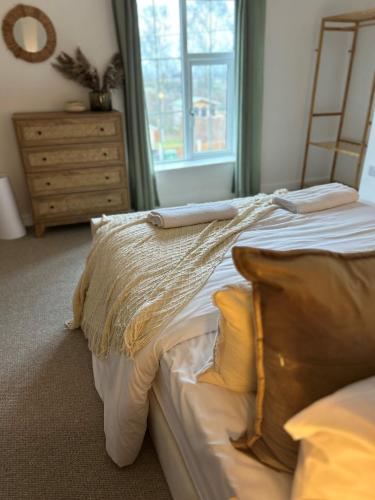 a bedroom with a bed and a dresser and a window at Trevose in Wrexham