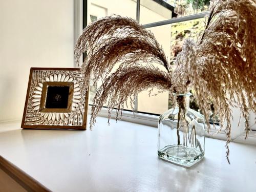 a glass vase sitting on a table next to a window at Trevose in Wrexham
