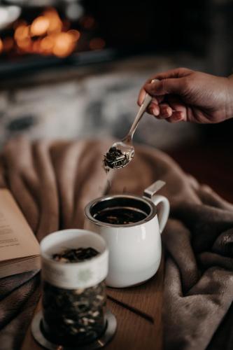 a person holding a spoon over a cup of coffee at Alpenappartements Cristall in Ehrwald