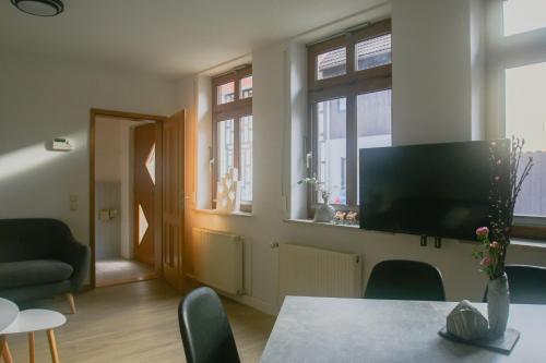 uma sala de estar com uma televisão e uma mesa e cadeiras em Ferienhaus Bomeier em Wernigerode