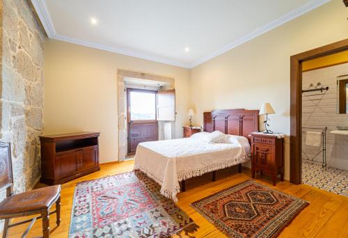 a bedroom with a bed and a bathroom with a tub at Casa Rural Pazo San Damian in Amoeiro