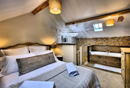 um quarto com uma cama grande e uma lareira em Blacksmith’s Barn - Cosy, Chilled & Dog Friendly. em Wykeham