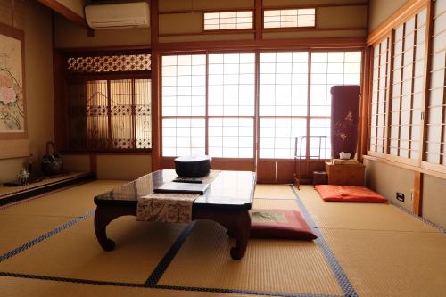 a room with a table in a room with windows at Hinodeya in Ito