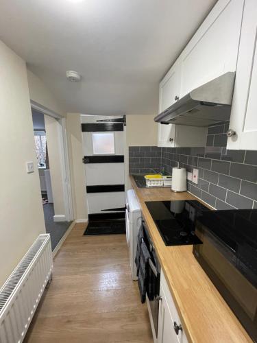 a kitchen with white cabinets and a counter top at Riverside Cottage in Kent