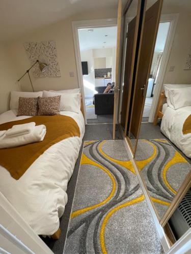1 dormitorio con 2 camas y espejo en Riverside Cottage en Kent