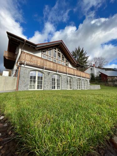 a house with a large lawn in front of it at Ferienwohnung Blick Thyratal Obergeschoss in Stolberg i. Harz