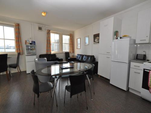 a kitchen and living room with a glass table and chairs at The Waterfront in Greenock