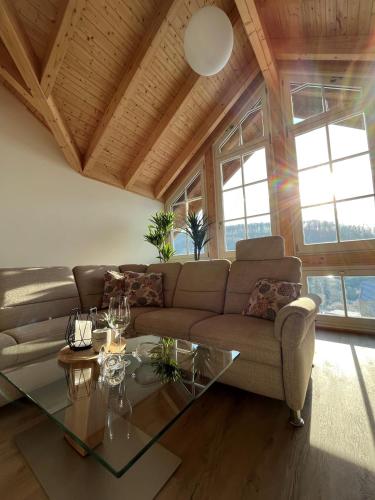 a living room with a couch and a glass table at Ferienwohnung Blick Thyratal Obergeschoss in Stolberg i. Harz