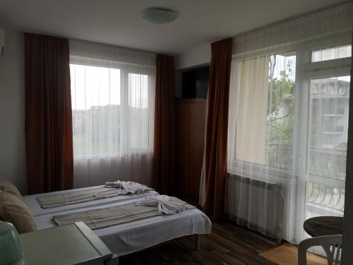 a bedroom with a bed and a large window at Miraj-MD in Primorsko