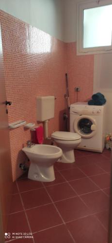 bagno con servizi igienici e lavatrice. di Casa Domenica a Torre Lapillo