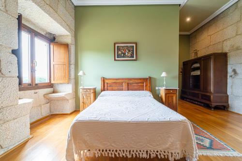 a bedroom with a large bed in a room at Casa Rural Pazo San Damian in Amoeiro