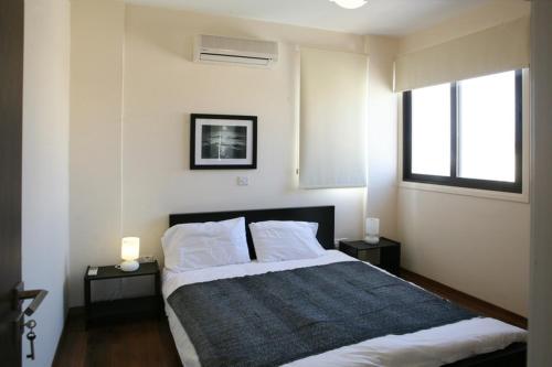 a bedroom with a large bed with two night stands at Artemis Executive Suite in Larnaca