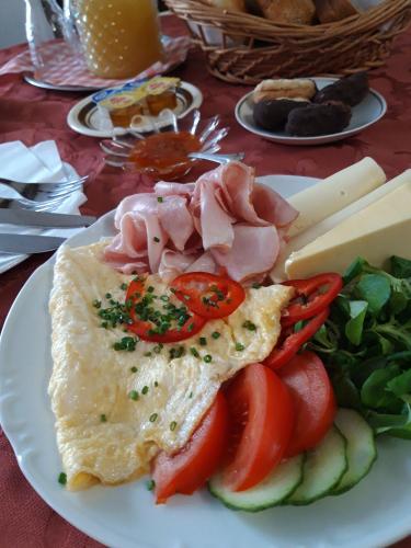 a plate of food with eggs and tomatoes and a salad at Hotel U Beránků in Libochovice
