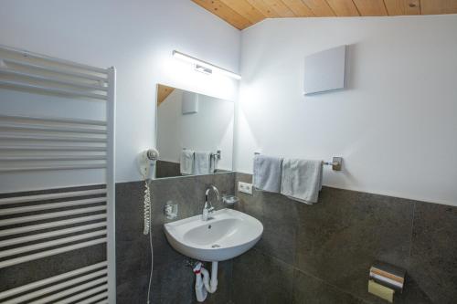 ein Bad mit einem Waschbecken und einem Spiegel in der Unterkunft Binterhof ROSALPINA APP in Kastelruth