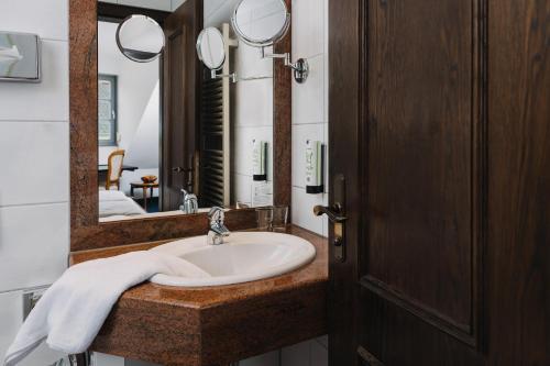 een badkamer met een wastafel en een spiegel bij Altstadthotel Arch in Regensburg