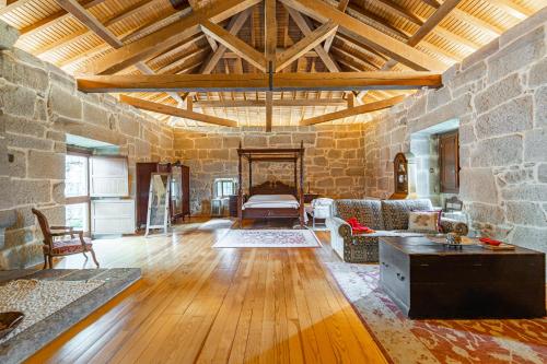 a large living room with a stone wall at Casa Rural Pazo San Damian in Amoeiro