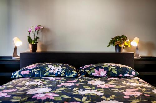a bedroom with a bed with two pillows and flowers at Chic and Freak Atelier in Como