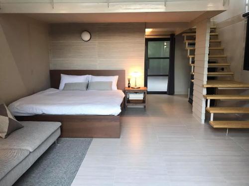 a bedroom with a bed and a staircase and a stair case at Onhill Village in Pong Talong