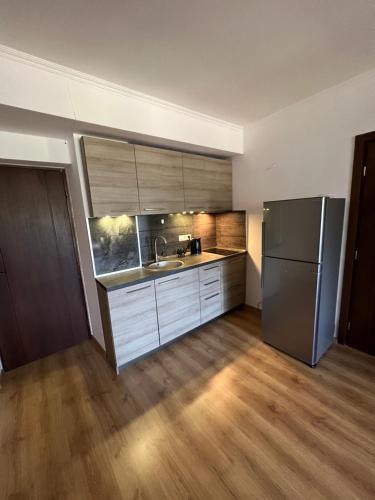 a kitchen with a stainless steel refrigerator and wooden floors at Apartment in Bakuriani in Bakuriani