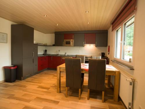 una cocina con mesa de madera y sillas. en Fewo am Hochscheid en Sankt Ingbert