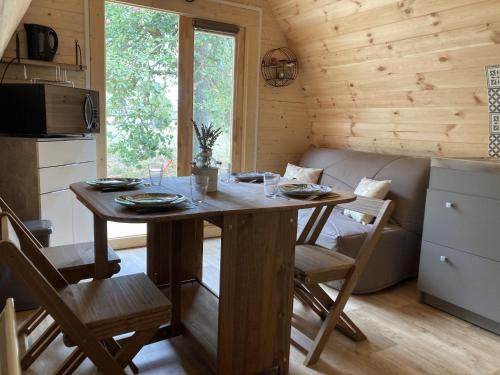une salle à manger avec une table et des chaises dans une cabine dans l'établissement Au pré des Alizés - insolite à la ferme des Alizés, à Vallon-sur-Gée