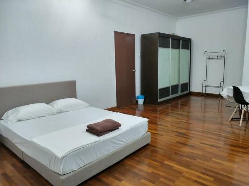 a bedroom with a white bed and a wooden floor at Sapporo Homestay in Skudai