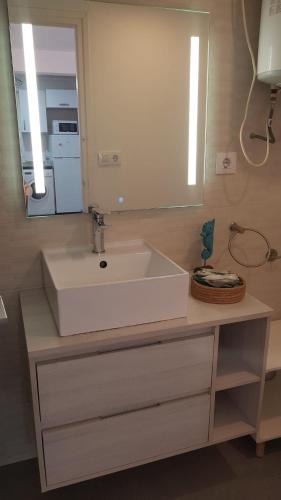 a bathroom with a white sink and a mirror at Apartamentos Hawaii - Parking y 50 mt del Arenal in Jávea