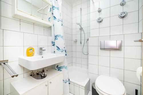 La salle de bains blanche est pourvue d'un lavabo et de toilettes. dans l'établissement Nettes Apartment in Würzburg, à Wurtzbourg