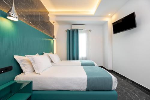 a bedroom with a bed with a green accent wall at Deluxe Suites Santorini in Fira