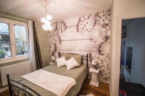 a bedroom with a bed with a wooden headboard at Les dames du pont in Pontgibaud