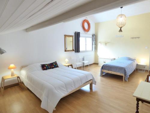 1 dormitorio blanco con 1 cama y 1 silla en L'OREE DE LA PLAGE, 15 pers, Charmante Maison rénovée à Vieux-Boucau, en Vieux-Boucau-les-Bains