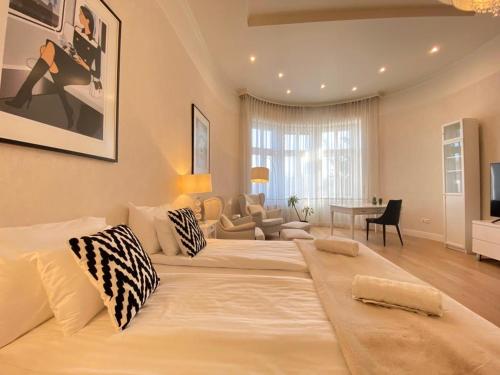 1 cama blanca grande en una habitación con sala de estar. en Romantic riverview bestern en Szeged