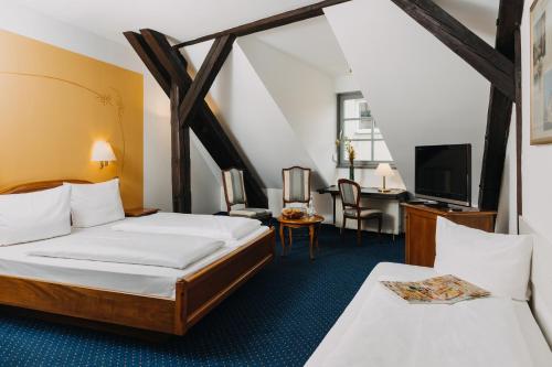 a hotel room with two beds and a tv at Altstadthotel Arch in Regensburg