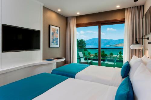 a hotel room with a bed and a large window at Elite World Marmaris - Adult Only in Marmaris