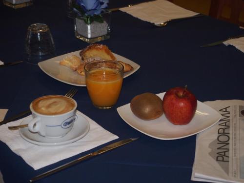 a table with plates of food and a cup of coffee and fruit at Hotel Resort Il Panfilo in Lago Patria