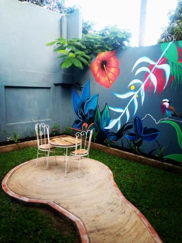 two chairs and a table in front of a mural at Fawlty Towers Accommodation & Activities in Livingstone