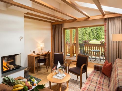 a living room with a couch and a table with a fireplace at BAD MOOS - Aqua Spa Resort in Sesto