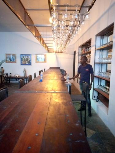 a man standing at the end of a long table at Fawlty Towers Accommodation & Activities in Livingstone